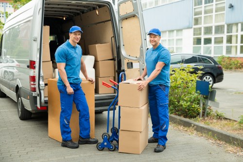 Local movers handling furniture on a narrow St Giles street